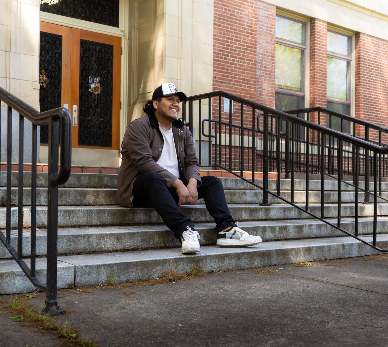 Bruno Salas Garcia sitting on the steps outside of Kidder Hall. 