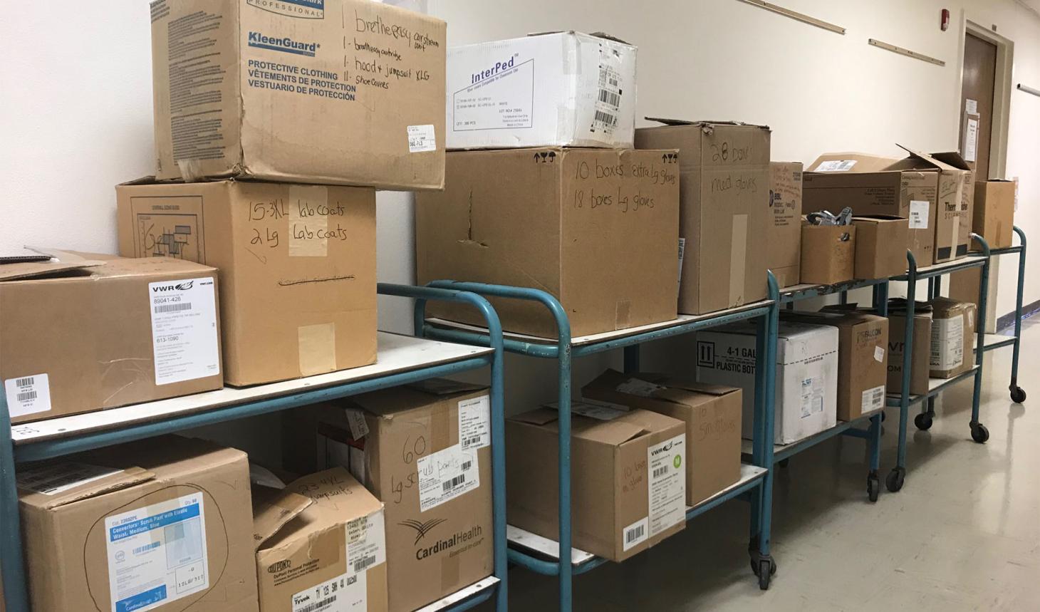 Boxes sitting on carts in hallway.