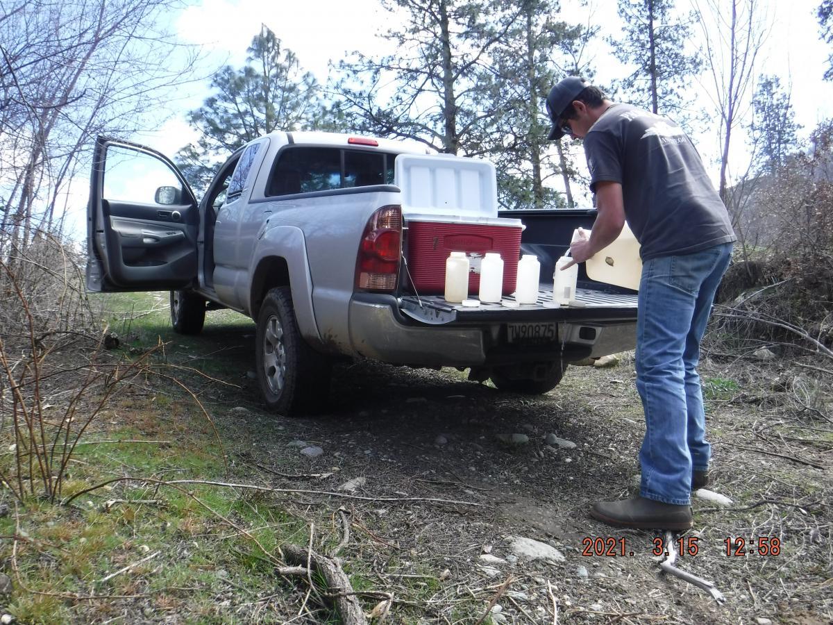 Scientist with water samples on truck bed