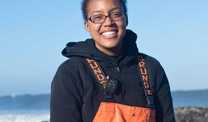 Courtney Jackson standing in rocks next to ocean shore