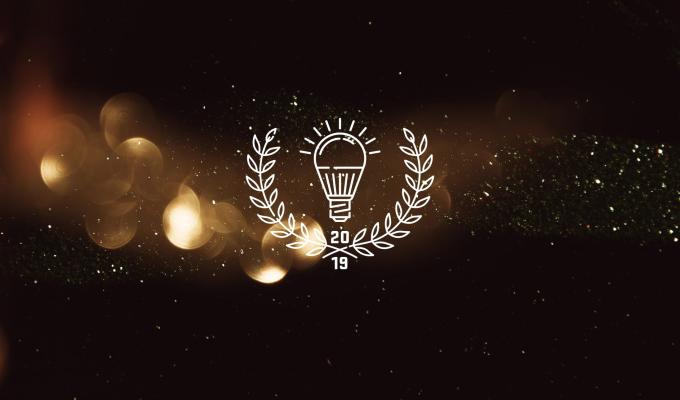 Light bulb and laurel icon labeled "2019" above light texture